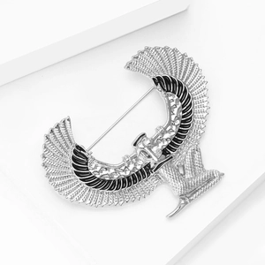 Detailed macro view of vintage silver Egyptian goddess brooch with black enamel inlay