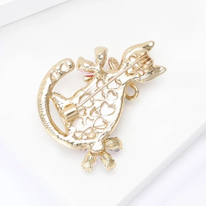 Detailed back view of a golden cat brooch showing the pin mechanism and heart cutouts