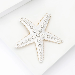 Vue détaillée d'une broche étoile de mer avec strass brillants et base dorée élégante