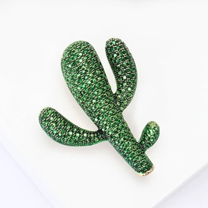 Spilla cactus chic con strass verdi scintillanti su un supporto bianco