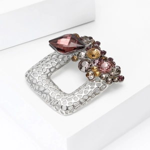 Detailed macro view of a vintage hollow square brooch with purple rhinestone inlay