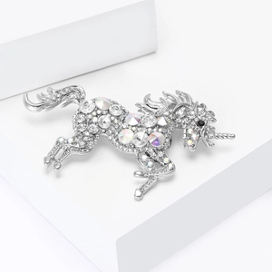 Detailed close-up of a silver unicorn brooch featuring sparkling iridescent rhinestones
