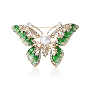 Broche papillon dorée de luxe avec ailes en émail, cristaux brillants et perle blanche