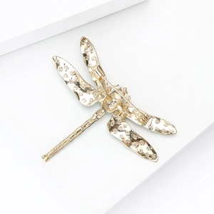 Detailed back view of golden enamel dragonfly brooch with secure rotating safety pin