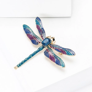 Close-up of luxury dragonfly brooch with blue gradient enamel and micro-set crystals