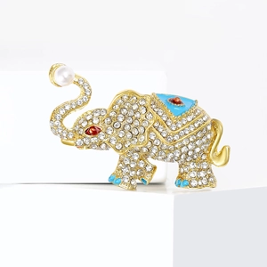 Luxurious elephant brooch with sparkling crystals, blue enamel saddle, and a white pearl accent