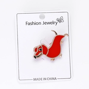 Detailed view of a red enamel dachshund brooch with gold-tone beaded metal edges