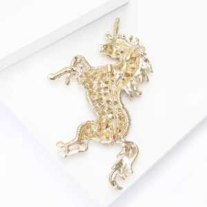 Detailed back view of unicorn brooch featuring gold plating and secure safety clasp