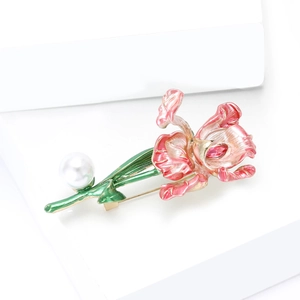 Détail de la broche fleur en émail rose avec feuilles vertes et accent de perle blanche