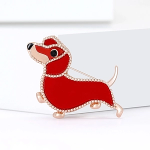 Creative dachshund brooch with red enamel and rose gold details on a minimalist background