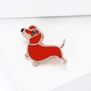 Detail of dachshund brooch with red enamel and rose gold metallic outline on white base