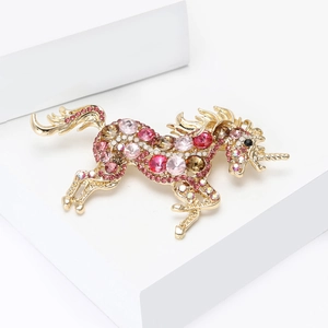 Macro view of crystal encrusted unicorn brooch featuring colorful gradient rhinestones