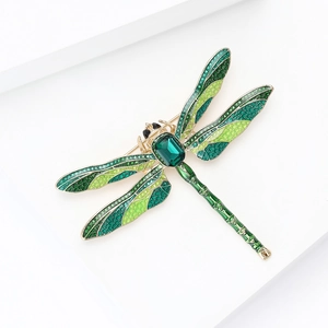 Detailed close-up of emerald-green dragonfly brooch wings with fine enamel texture