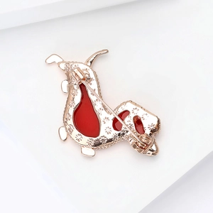 Elegant gold plated dog brooch with red enamel finish and detailed snowflake engraving