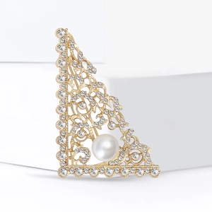 Elegant gold triangle brooch with sparkling rhinestones and white pearl on white blocks