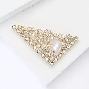 Macro shot of triangle brooch with sparkling rhinestones and a large white pearl detail