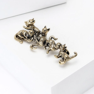 Detailed view of vintage alloy cat brooch with five playful kittens on white pedestals