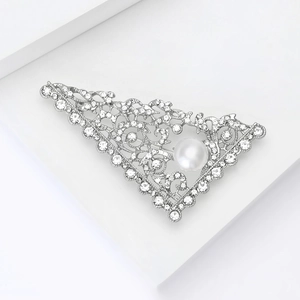 Detail view of silver hollow vintage brooch with sparkling rhinestones and white pearl