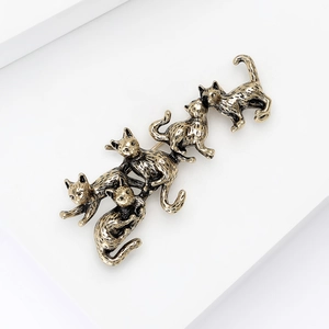 Detailed macro shot of vintage gold kitten brooch set with artistic climbing cat design