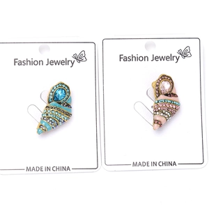 Detail of luxury rhinestone conch brooches in blue and pink on display card