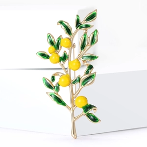 Elegant enamel lemon tree brooch with yellow fruit and green leaves on white background