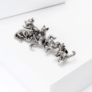 Detailed close-up of retro silver cat brooch featuring five kittens in artistic relief