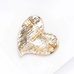 Elegante spilla a cuore dorata con strass che mostra la chiusura a spilla sul retro