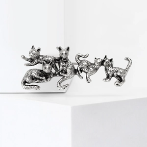 Vintage silver cat brooch with five playful kittens on a minimalist white platform