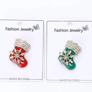 Detail view of red and green enamel Christmas stocking brooches with sparkling crystals