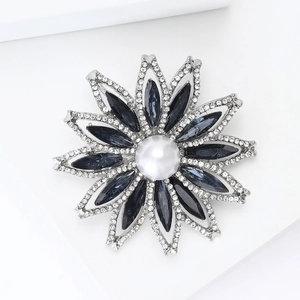 Détail de broche tournesol avec cristaux bleus et perle blanche centrale