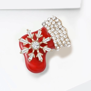 Detail of red enamel Christmas stocking brooch with sparkling crystals on gold metal