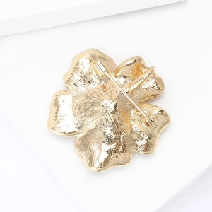 Detailed back view of flower brooch showing metal brushed texture and safety pin clasp