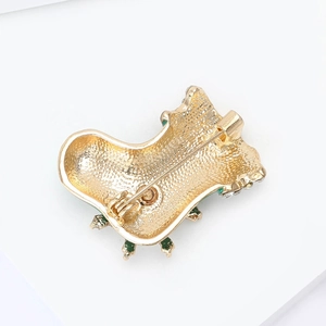 Detail view of the Christmas stocking brooch showing the gold alloy back and safety pin clasp