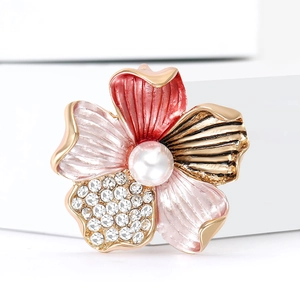 Elegant floral enamel brooch with crystal petals and pearl center on a minimalist white stand