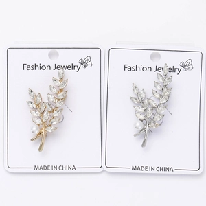 Détail de broches en forme d'épi de blé dorées et argentées avec cristaux et perles