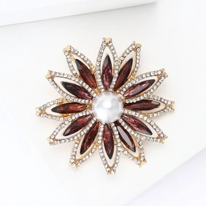 Détail de la broche tournesol avec cristaux bordeaux, perle blanche et strass étincelants