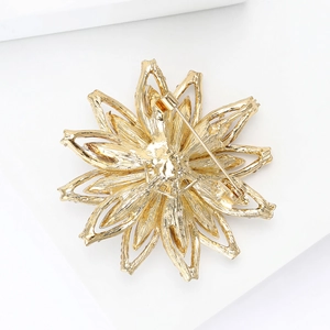 Détail de l'arrière de la broche fleur dorée montrant le fermoir et le métal texturé