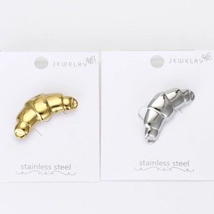 Macro detail of gold and silver croissant brooches on jewelry display cards
