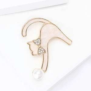 Broche chat dorée chic avec incrustation marbre rose et perle blanche sur support blanc