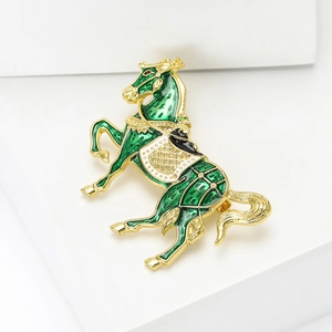 Dettaglio della spilla a cavallo dorata con smalto verde, strass e posa in movimento