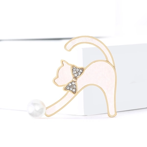 Élégante broche chat en émail rose avec perle et cristaux sur un support blanc épuré