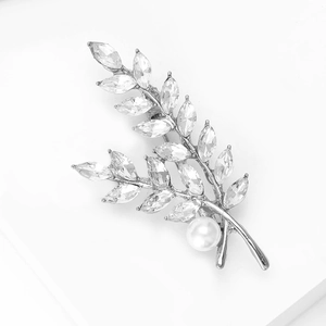 Détail de la broche feuille en cristal avec base argentée et perle blanche