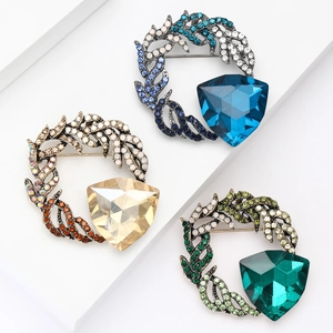 Elegant round glass wreath brooch with crystal stones in blue champagne and green colors