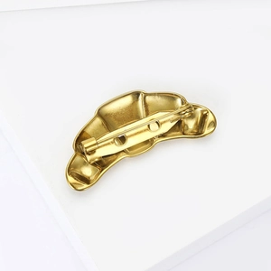 Detailed back view of gold-plated croissant brooch with secure pin clasp and hinge mechanism