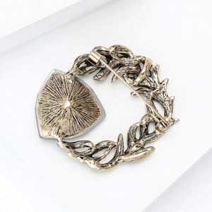 Retro gold alloy wreath brooch with shield-shaped grey inlay and secure safety pin back
