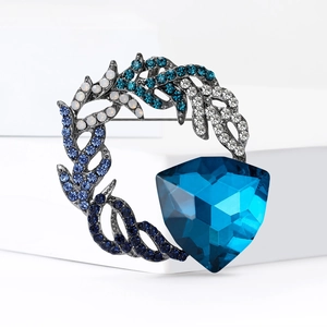 Vintage style wreath brooch featuring large blue crystal and gradient rhinestones