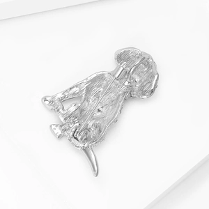 Detailweergave van de zilveren puppybroche met getextureerd metaal en veilige sluiting