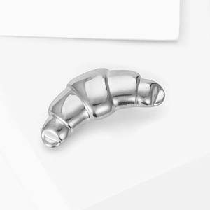 Macro shot of silver croissant brooch with polished mirror finish and realistic texture