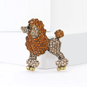 Broche caniche dorée sertie de strass ambrés et champagne sur des supports blancs