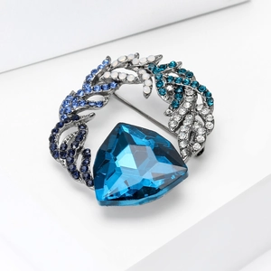 Detailed macro view of vintage silver brooch with large blue crystal and pavé rhinestones